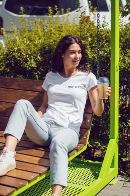 Photo d'une femme assise portant un t-shirt blanc avec le logo 